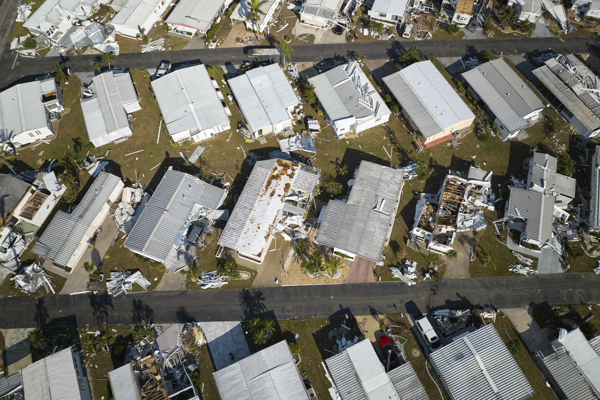 Badly damaged mobile homes after hurricane Ian in Florida residential area.