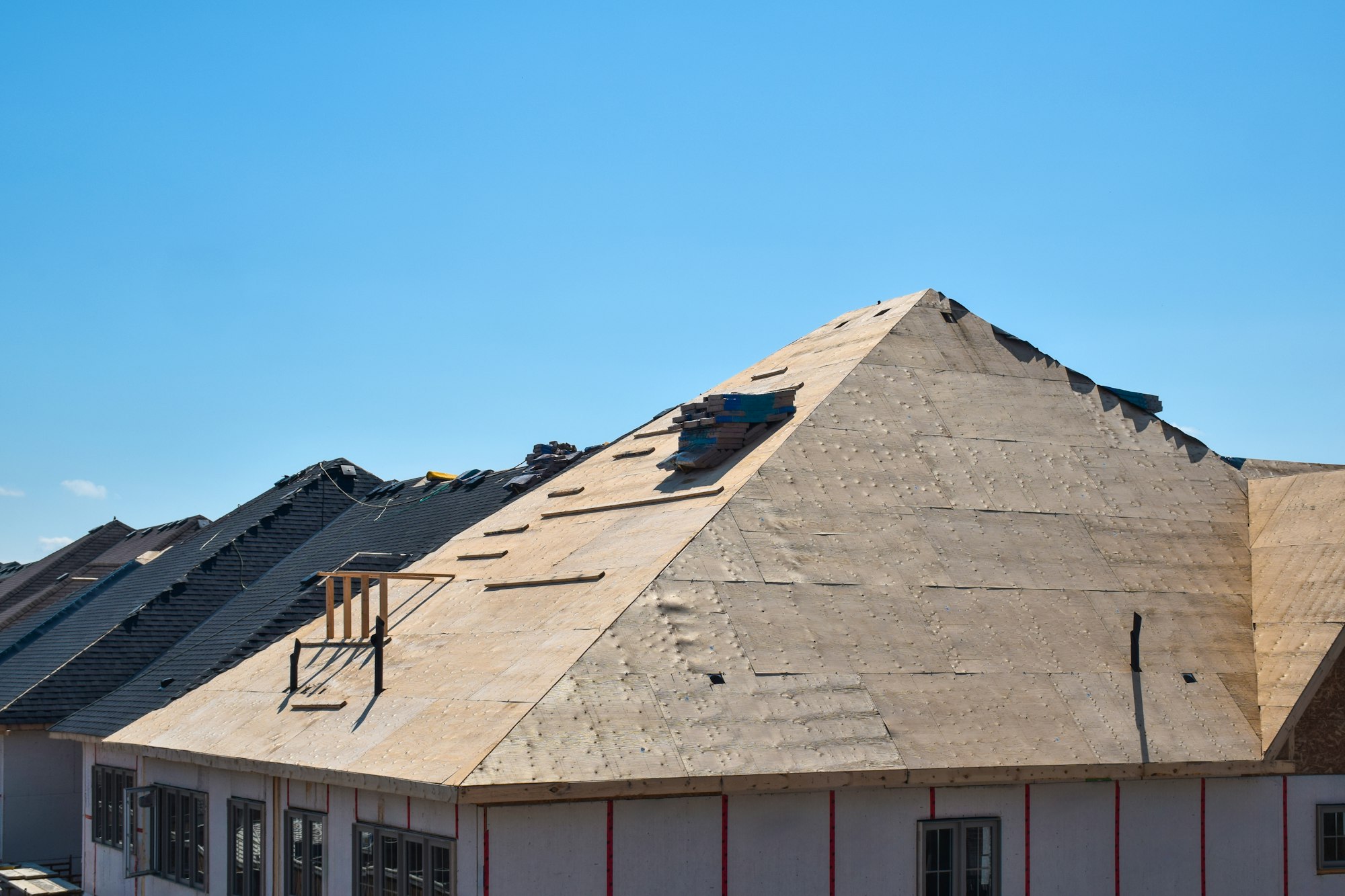 Plywood sheathing layer during roof building construction on new residential home